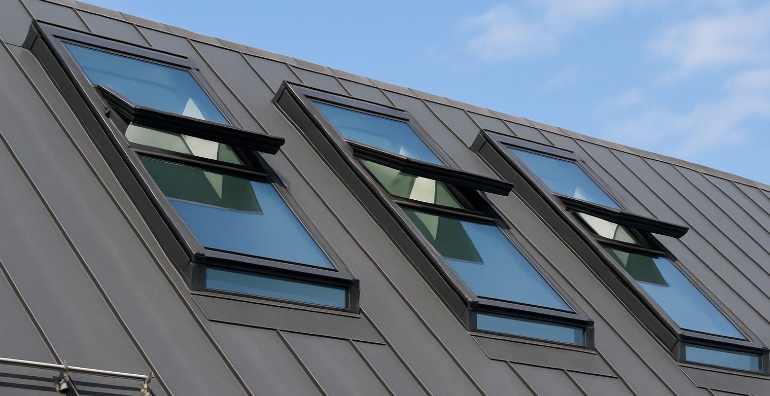 Ein Blechdach in anthrazit mit 3 großen Dachflächenfenstern