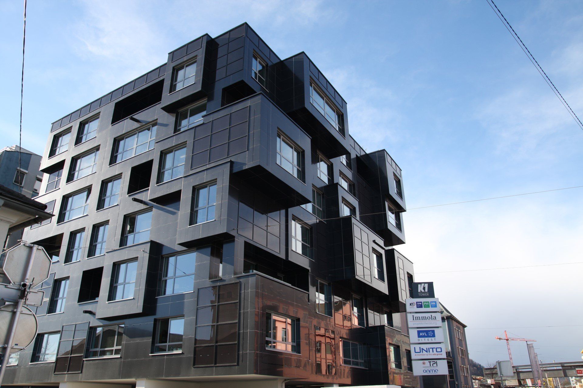 Der K1 Tower mit einer anthrazitfarbenen Metallfassade und vielen Fenstern, welche alle versetzt sind