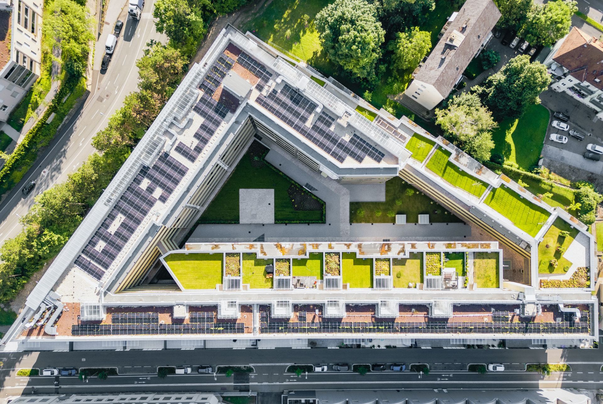 Ein Foto aus der Vogelperspektive von einem Wohnkomplex in Graz mit Dachbegrünung und PV Modulen